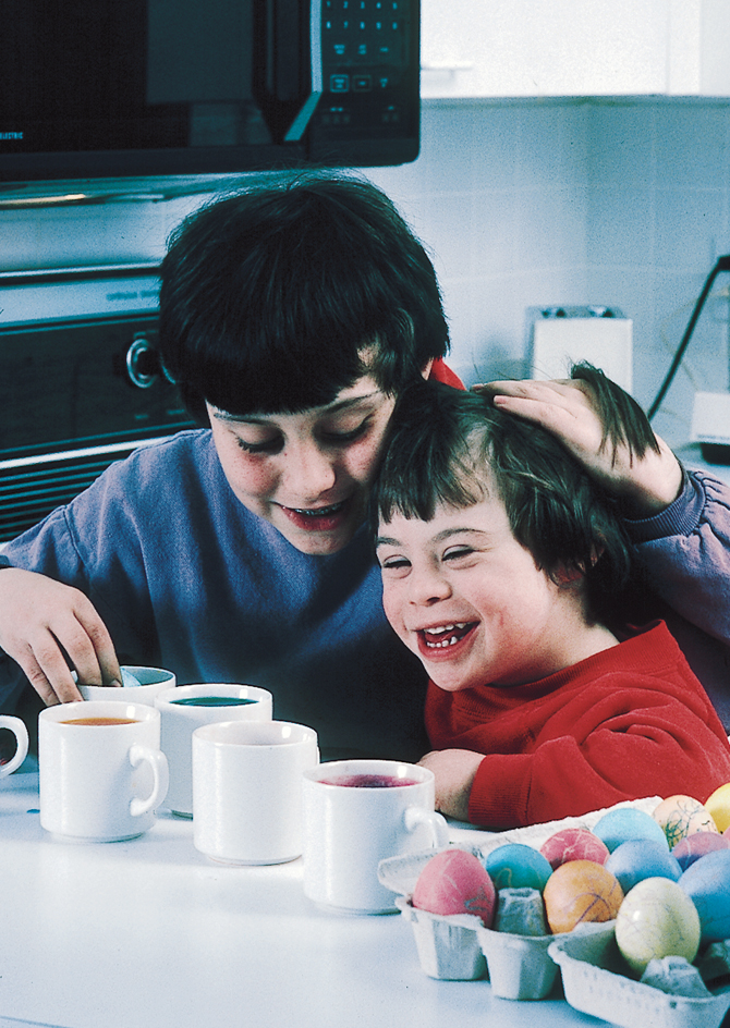 A child with Down syndrome colors Easter eggs