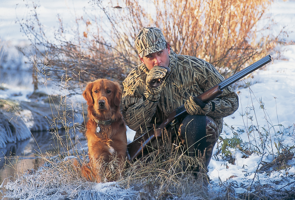 This hunter is using a duck call to attract his prey