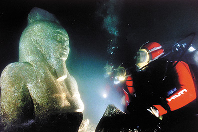 Underwater archaeologist studies a historic statue