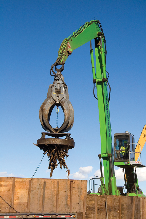 Crane with electromagnet moving scrap metal