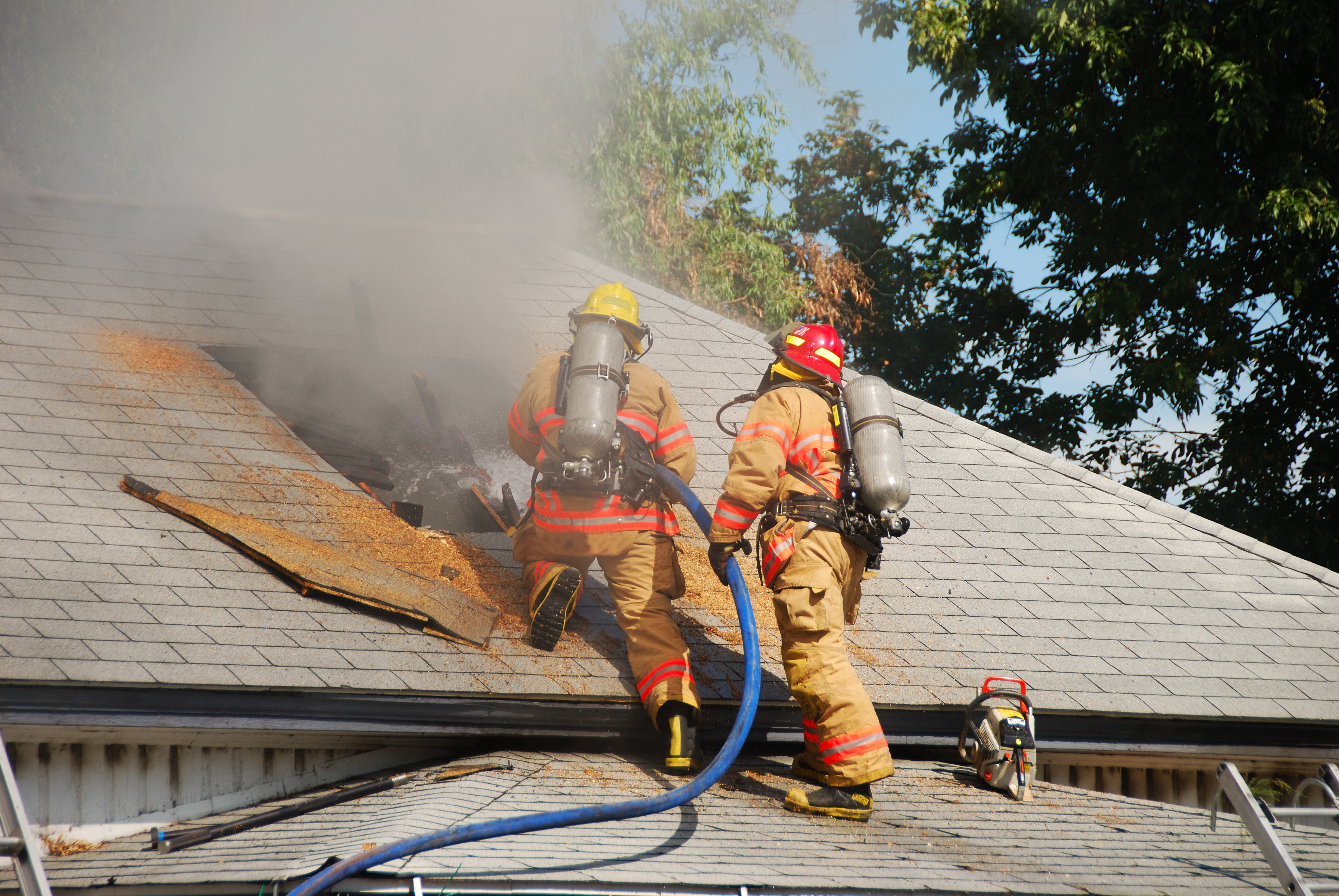 Firefighters ventilating a burning building