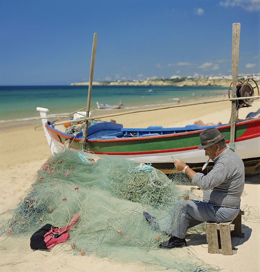 Fisherman mending a net in Portugal