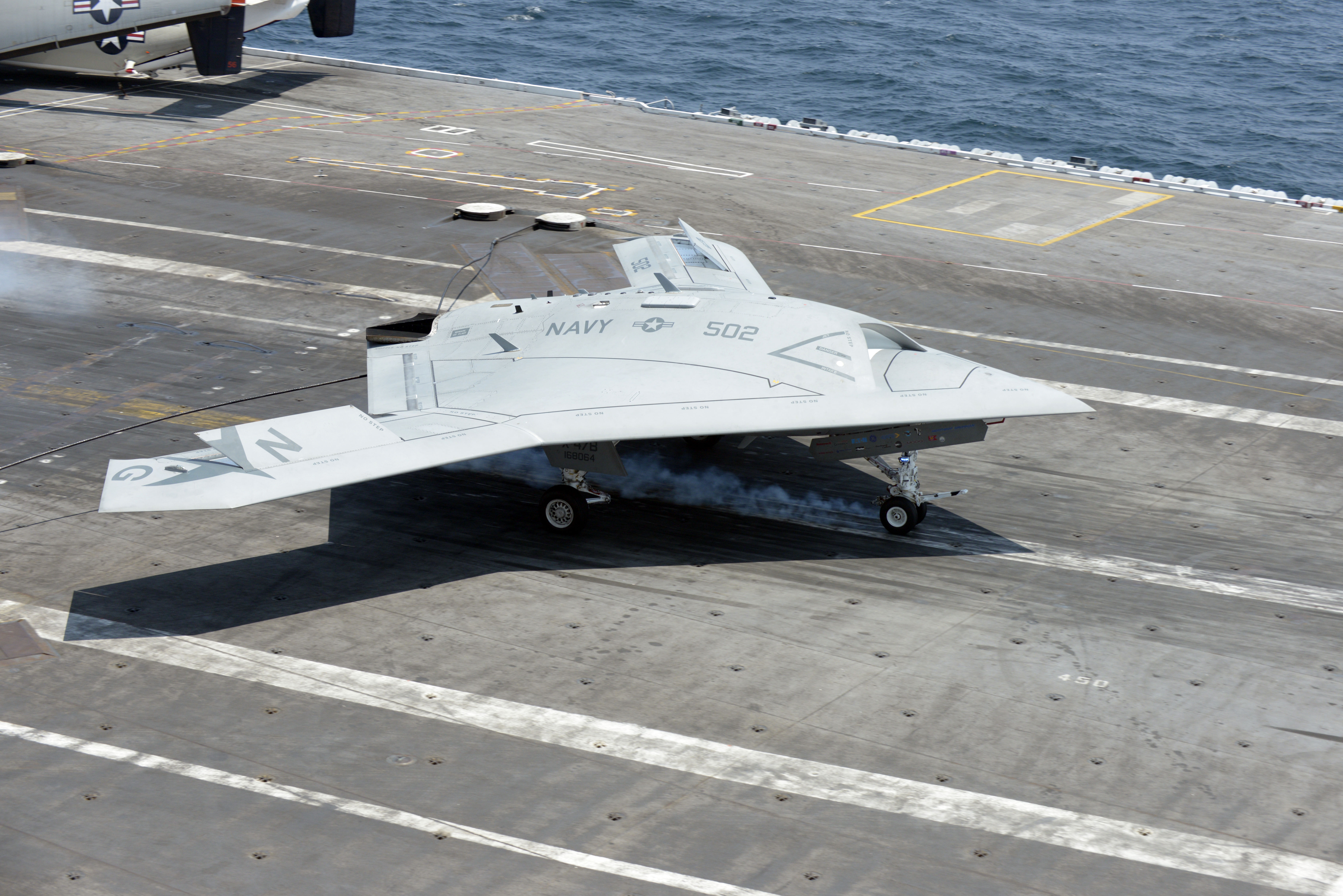 An unmanned aerial vehicle (UAV), also called a drone, landing on aircraft carrier