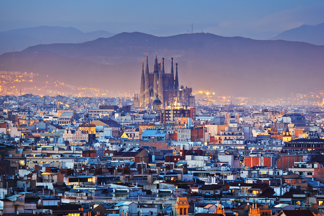 Rooftops and Sagrada Família cathedral at night, Barcelona, Spain