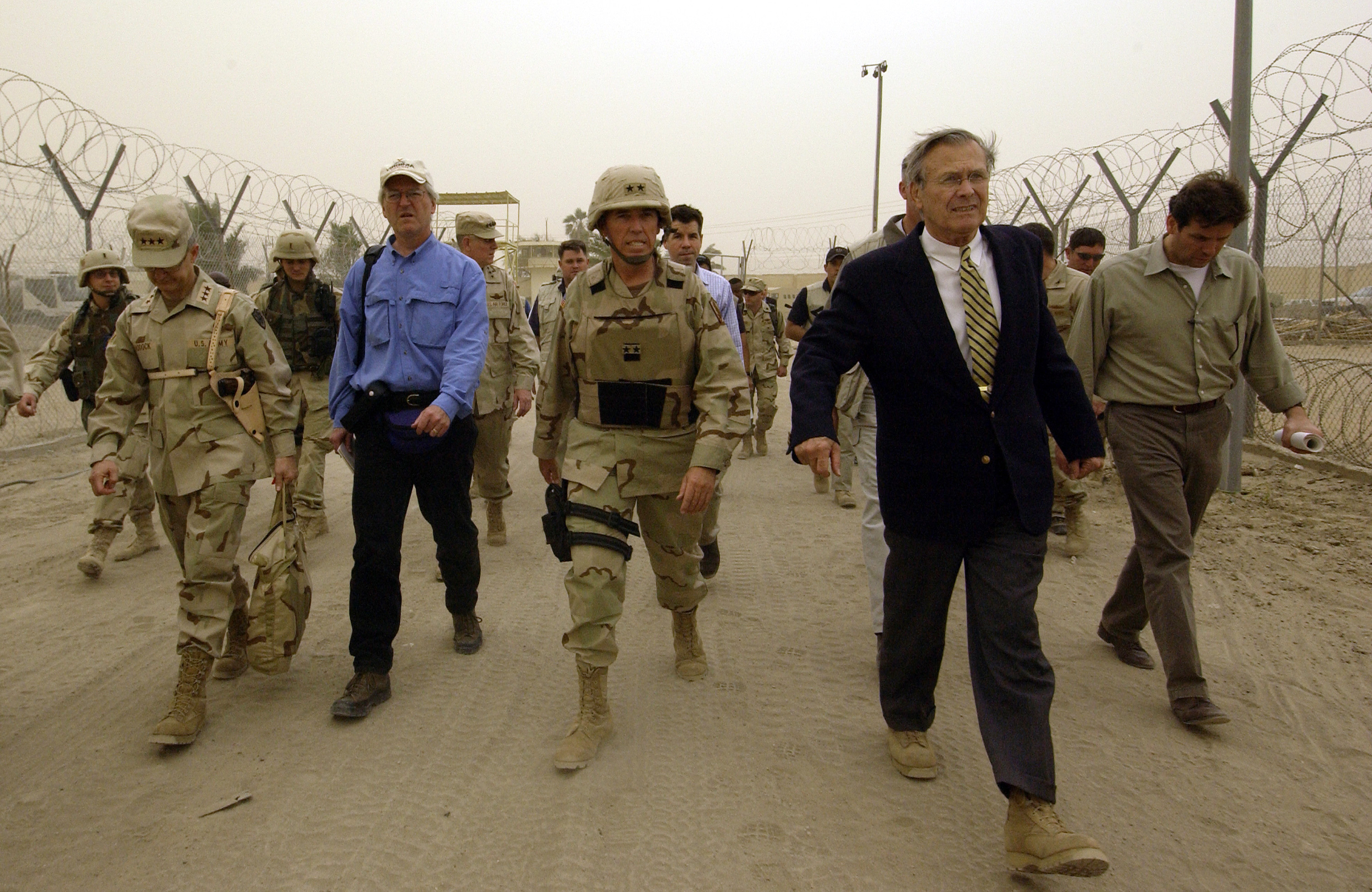 U.S. Defense Secretary Donald Rumsfeld (in suit) visiting Abu Ghraib prison in Iraq