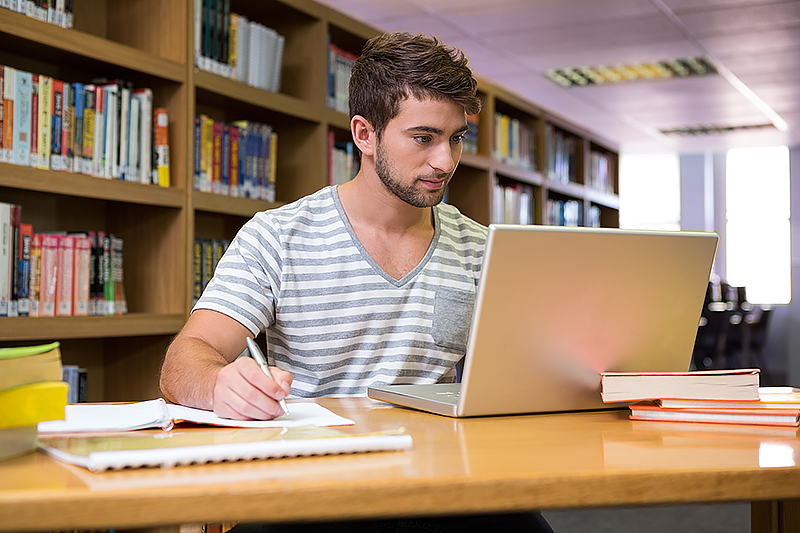 Student using a laptop in a university library