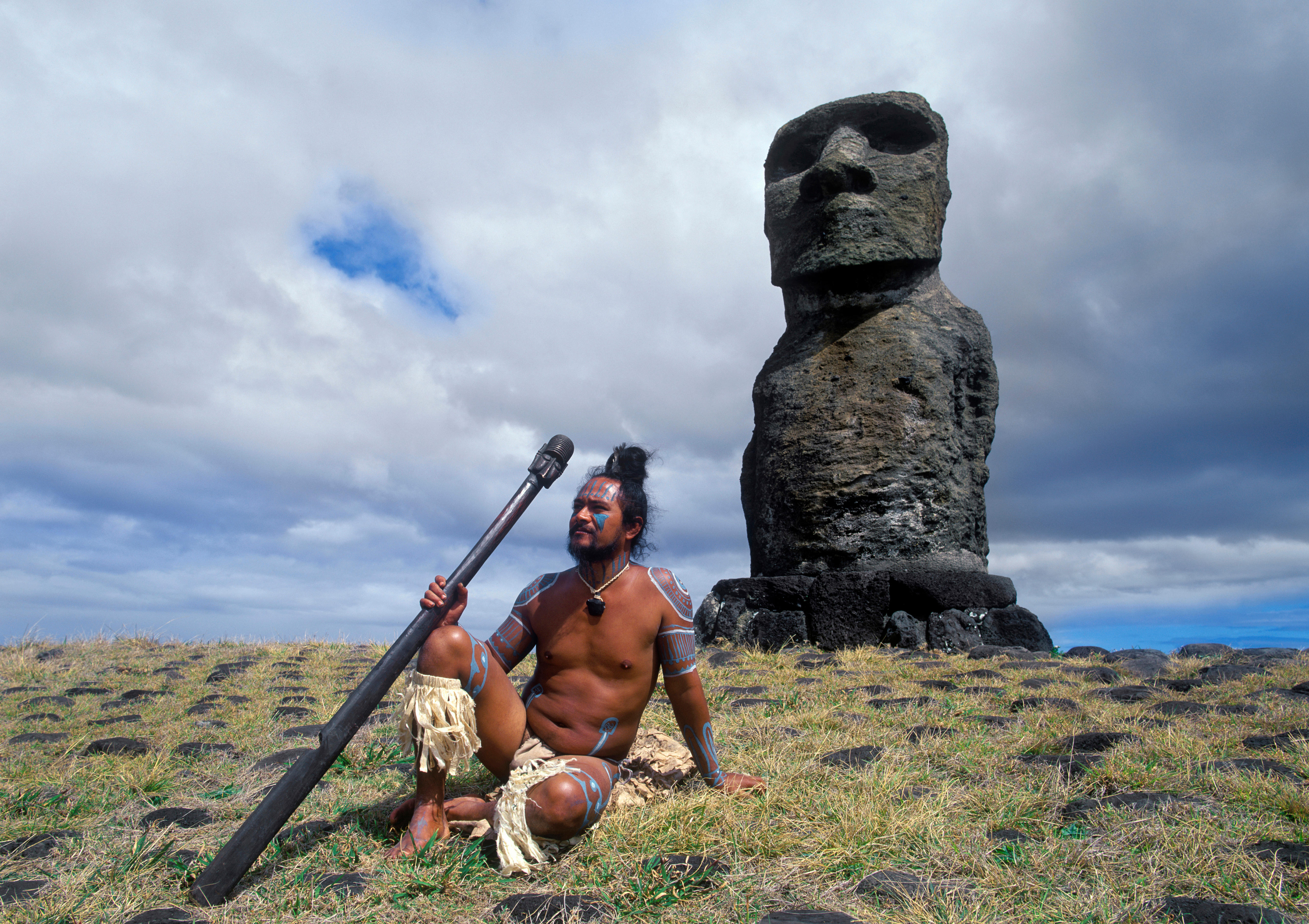 Stone statue and Easter Islander in traditional clothing