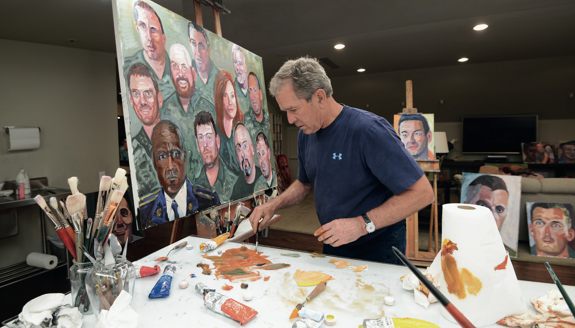 Former President George W. Bush painting a mural of U.S. military veterans