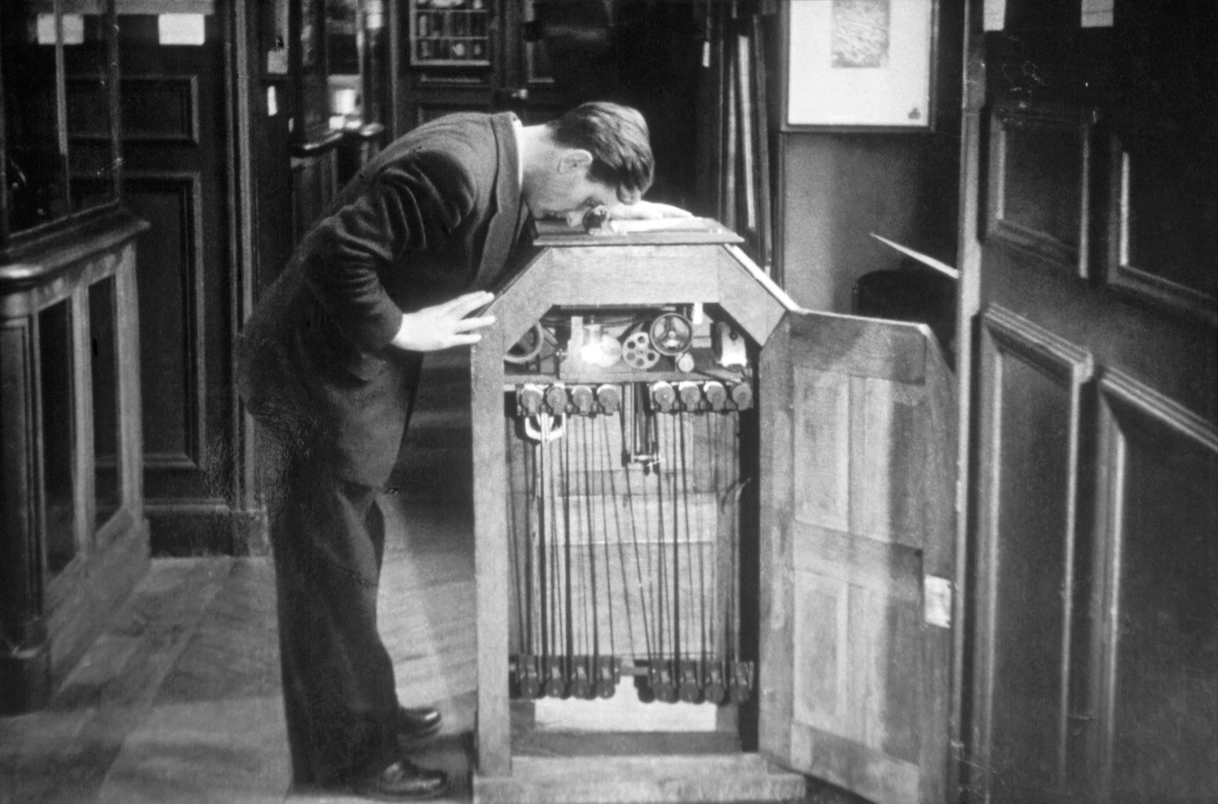 Man watching a motion picture with a kinetoscope