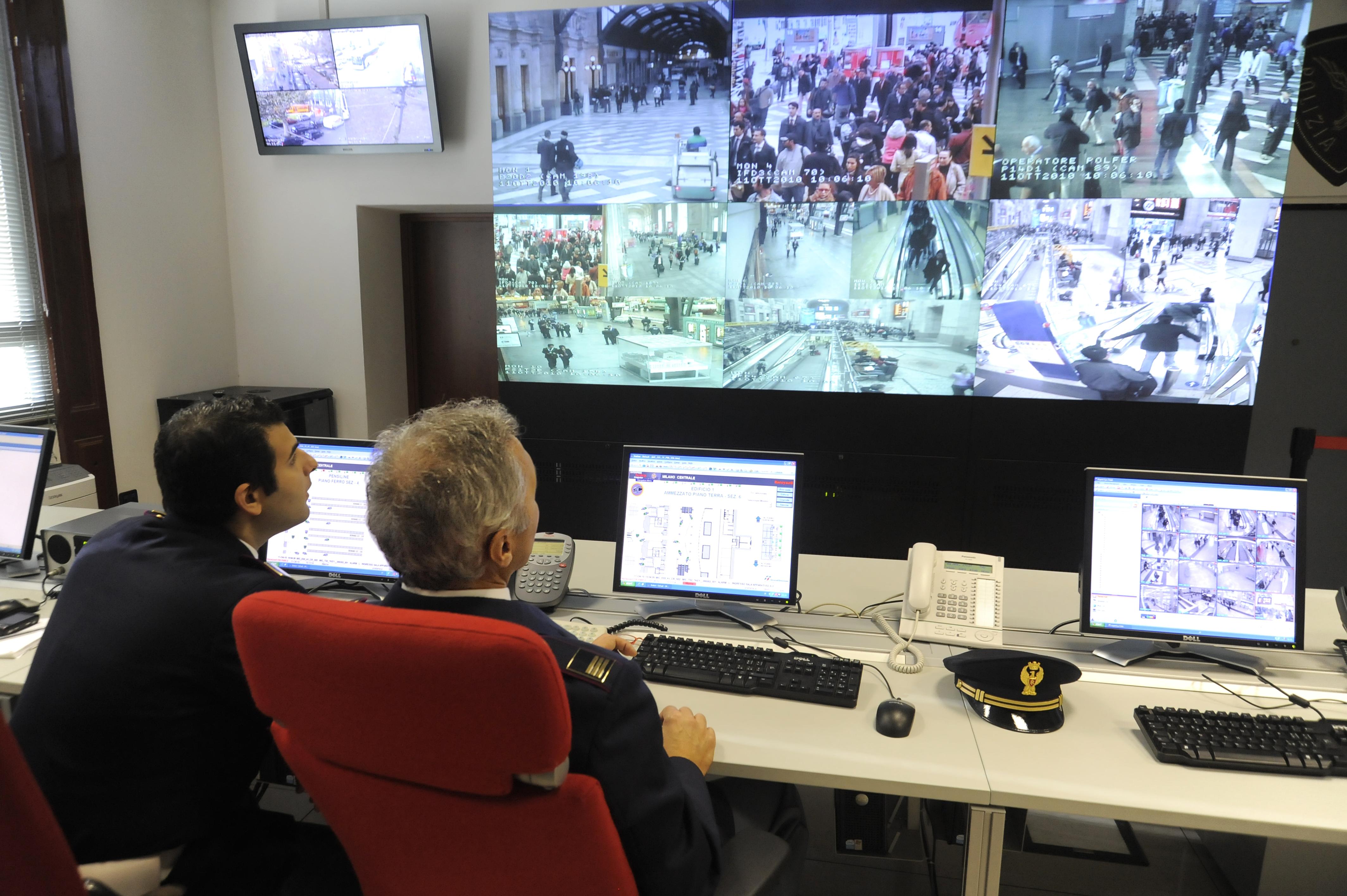 Police watching closed-circuit television at a train station