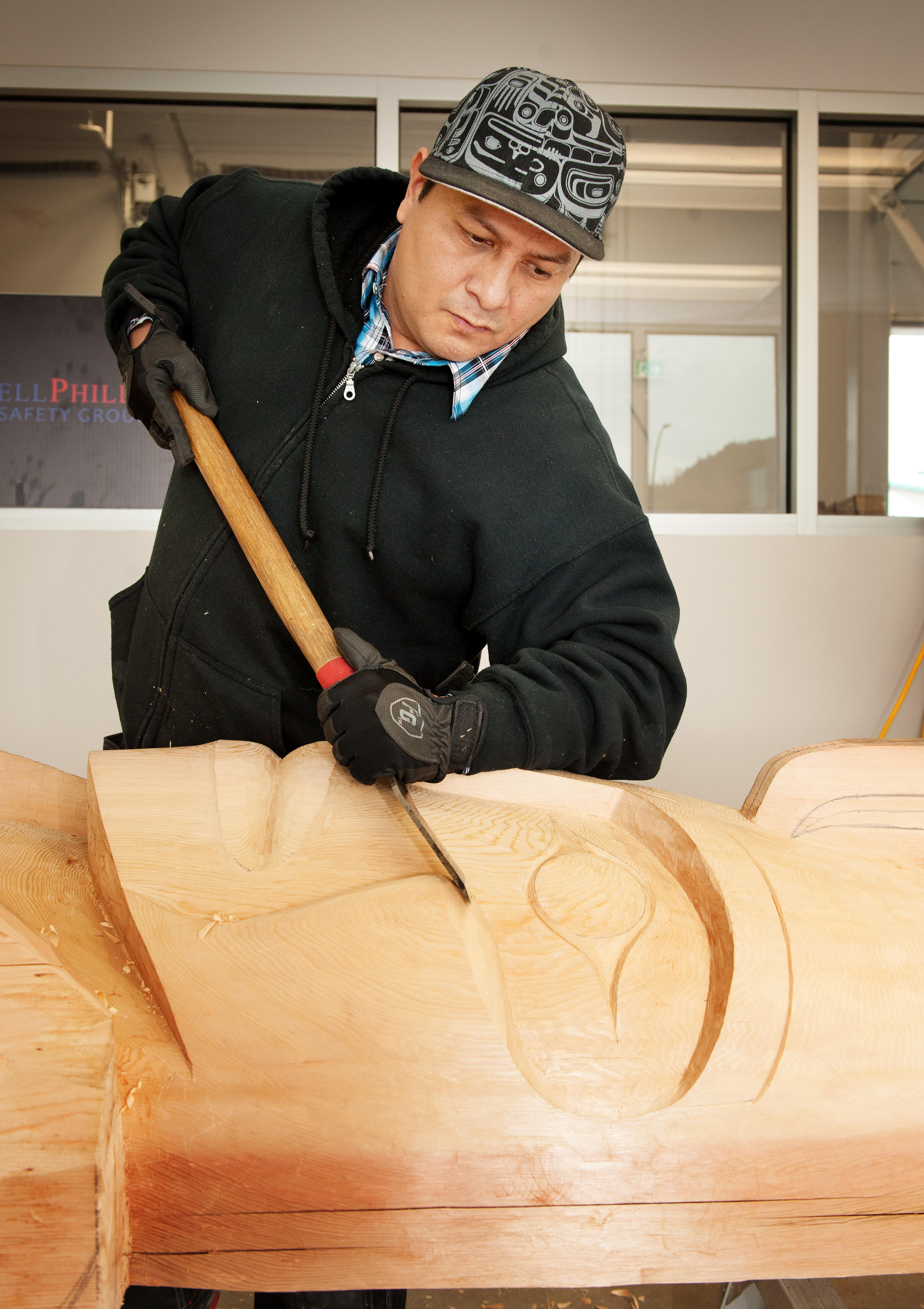 Squamish artist carving a totem pole