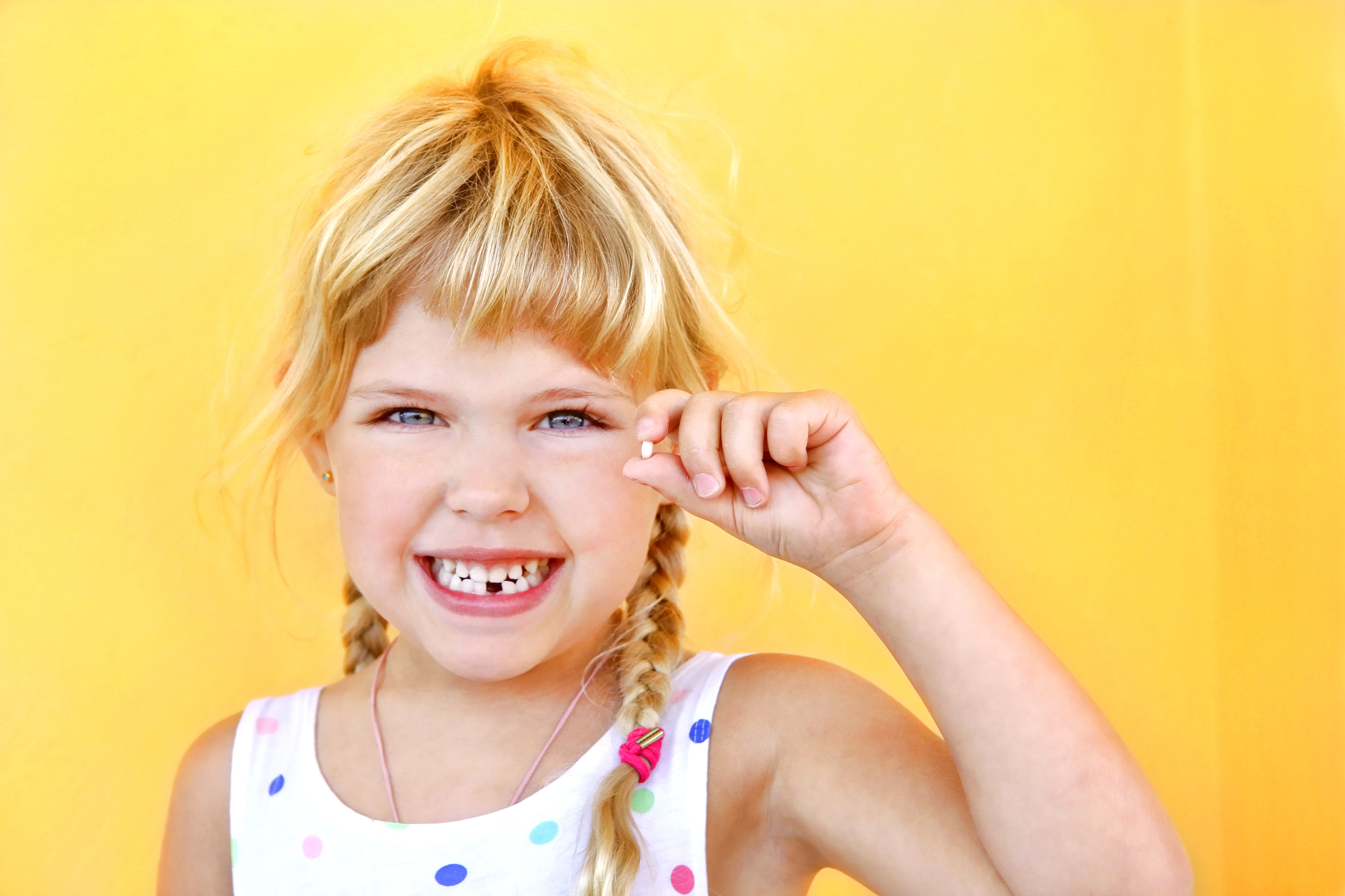 Child holding baby tooth