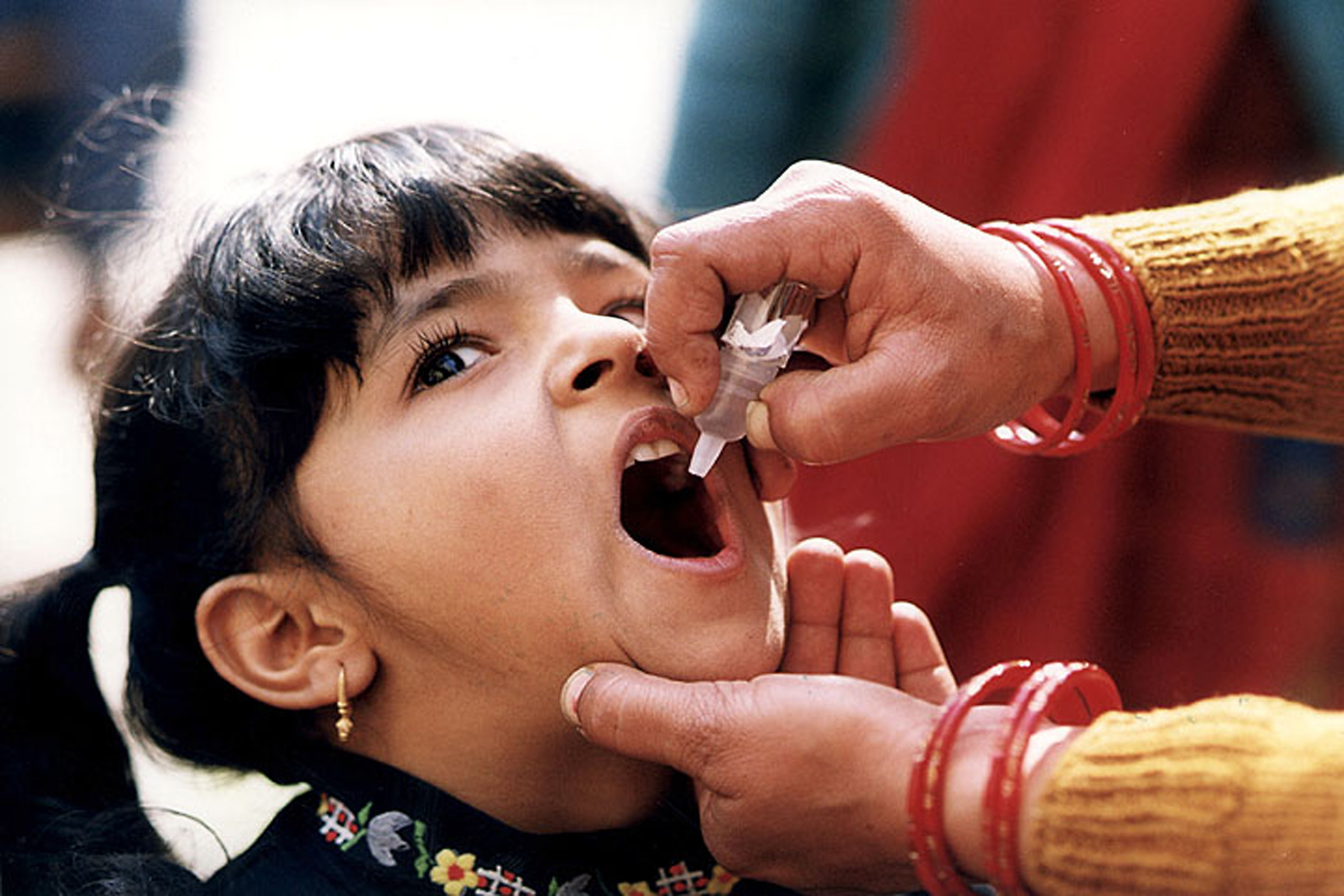 A child receives a dose of oral polio vaccine