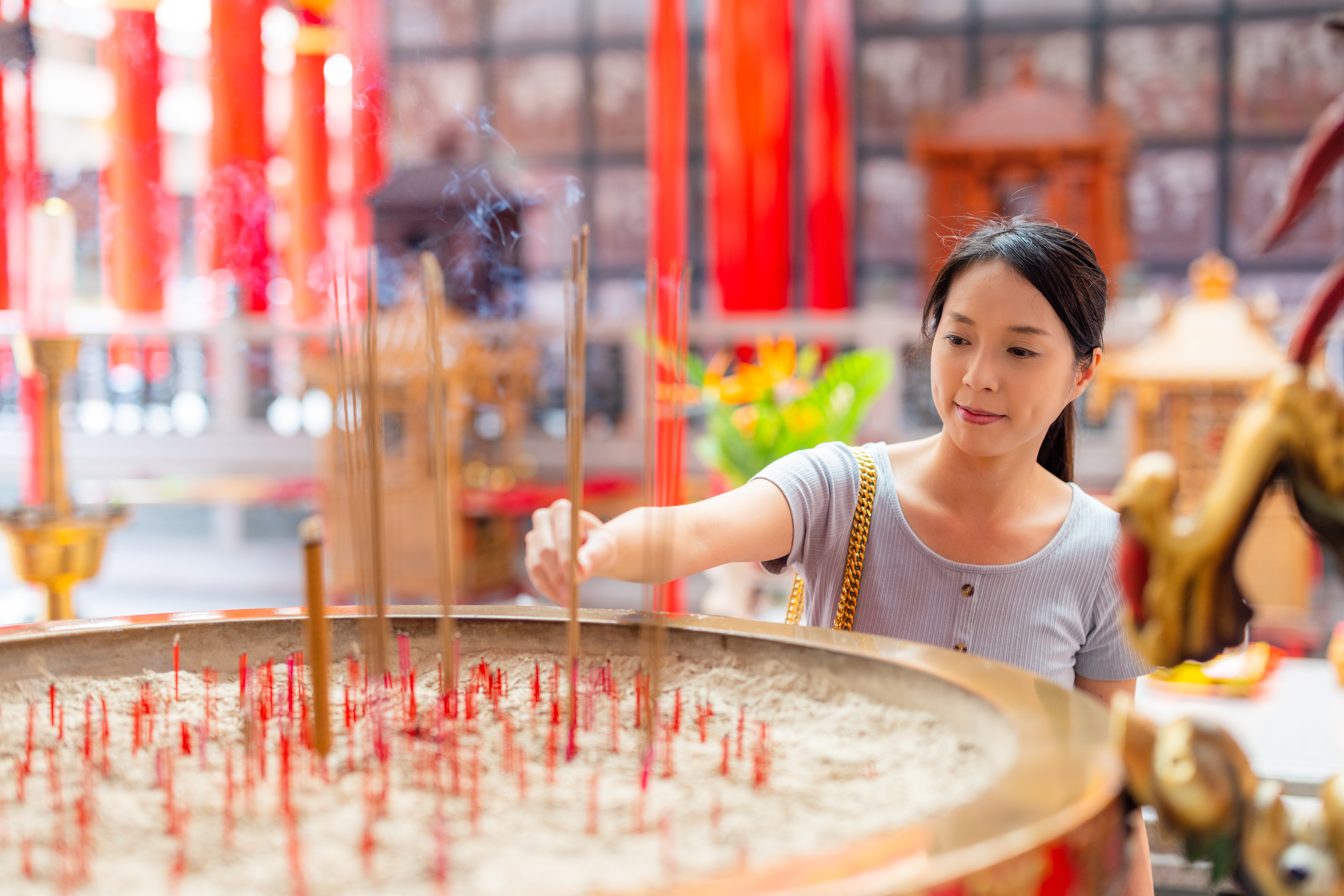 Woman offering incense at a Chinese temple